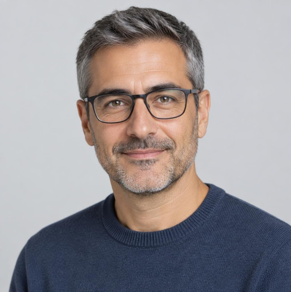 Studio portrait of a man with glasses and a sweater