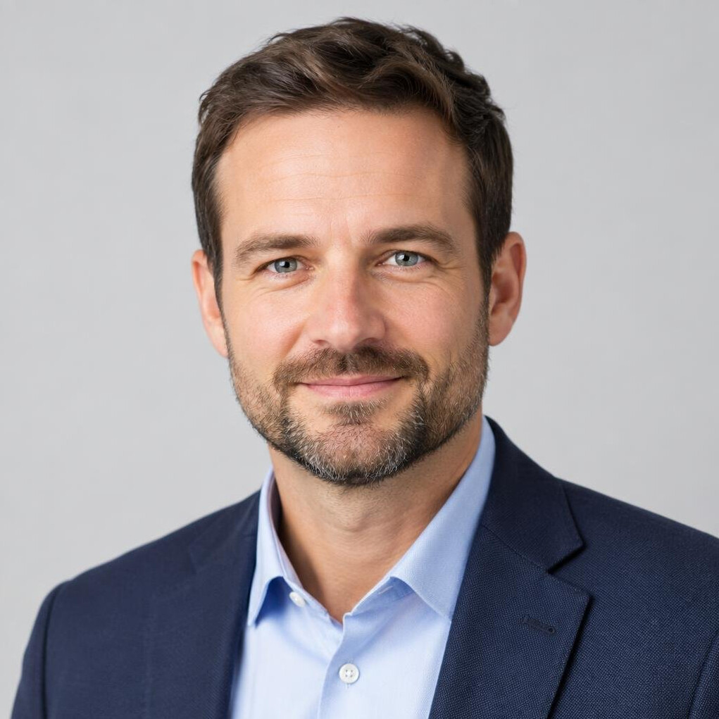 Studio portrait of a man with short beard in a shirt and blazer