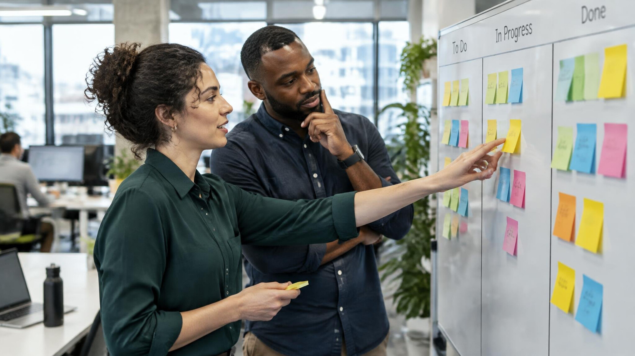 Colleagues aligning priorities on a kanban board