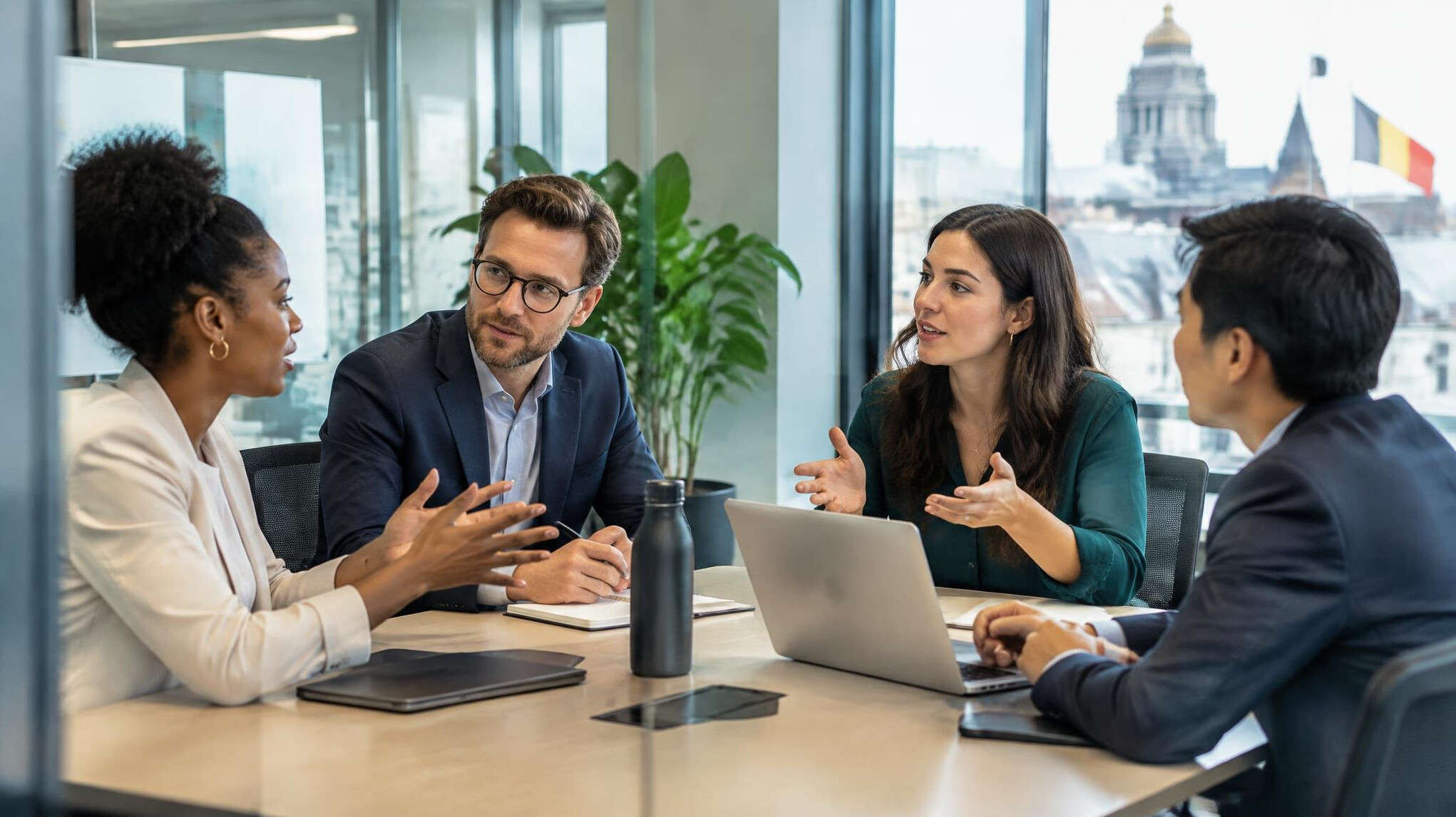 Team members having an open discussion in a glass meeting room